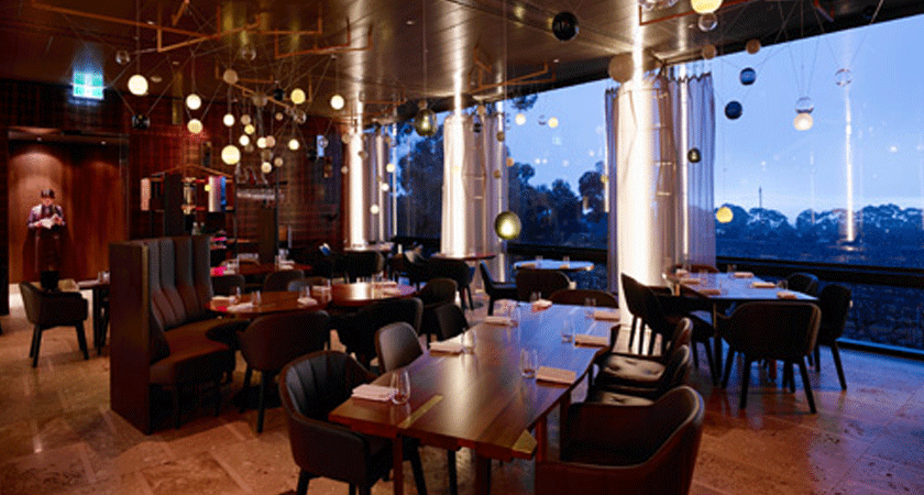 Interior of Magill Estate Restaurant. Wooden panels, wooden tables, leather seats and feature low hanging lights