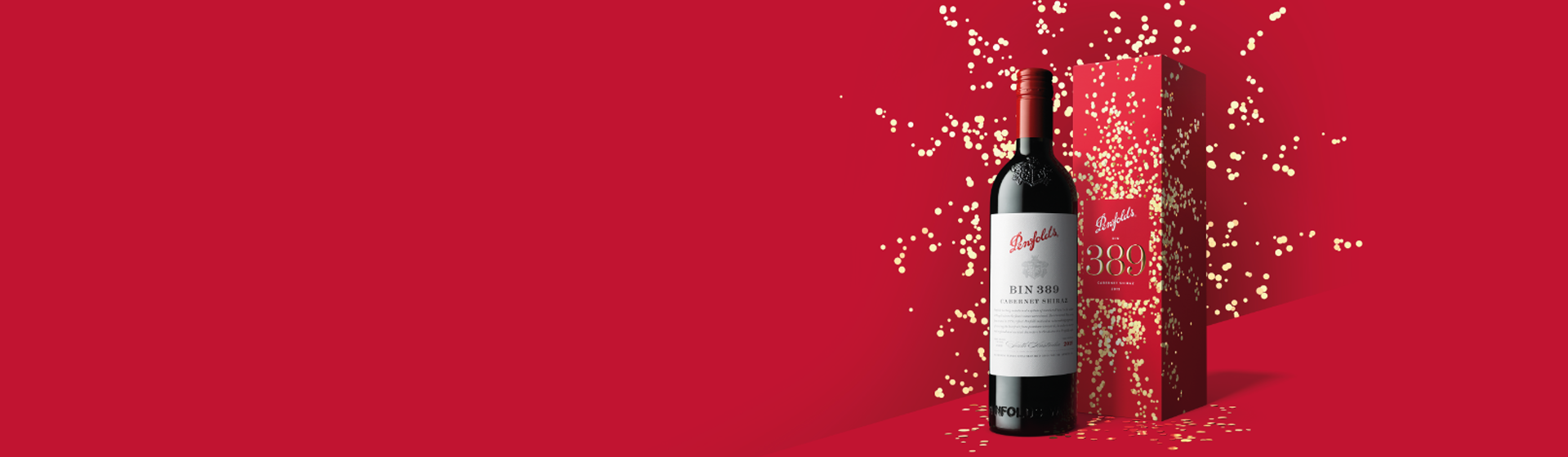 Bin 389 bottles and gift box against red background with gold confetti behind