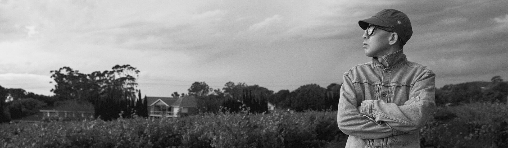 Black and white photo of Nigo standing in front of the vines at Penfolds Magill Estate