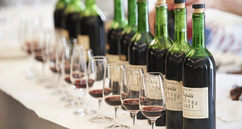 Line up of St Henri bottles, cork removed with sample glass in front