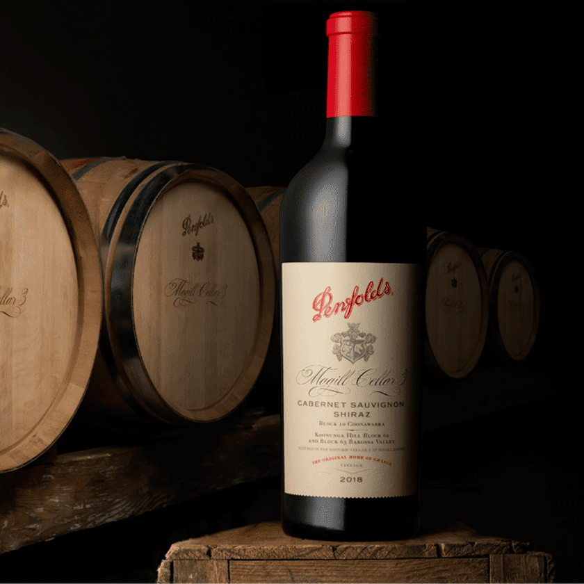 Magill Cellar 3 bottle in front of a row of barrels